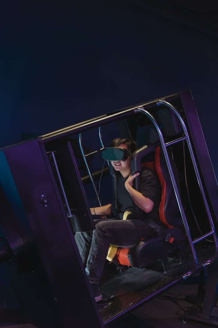 A person using a VR headset inside a motion simulator, immersed in virtual reality.
